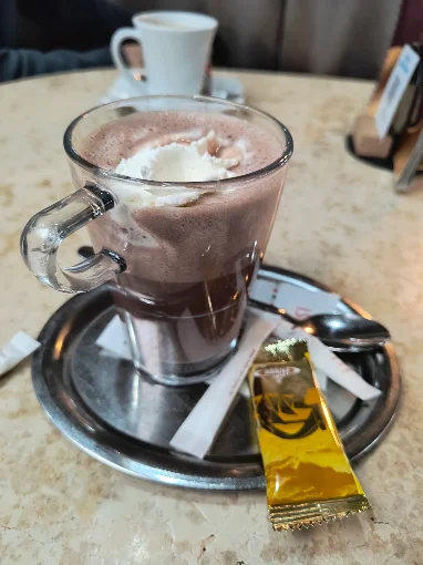 Glas Kakao mit Sahne auf einem silbernen Tablett