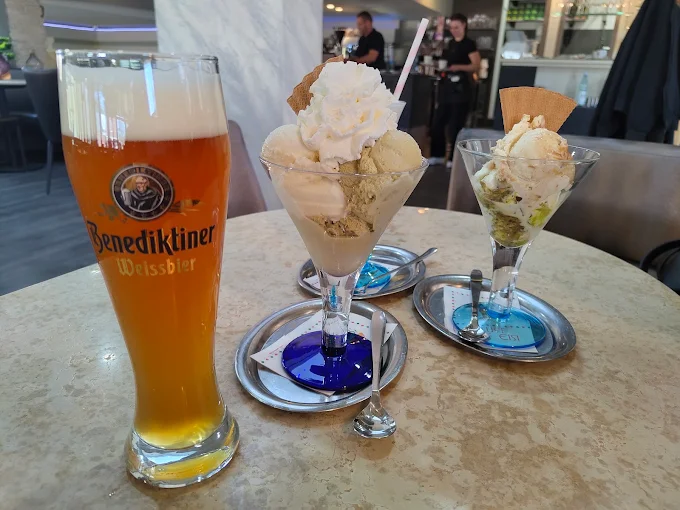 Zwei Eisbecher und ein Getränk auf einem Tisch im Eiscafé
